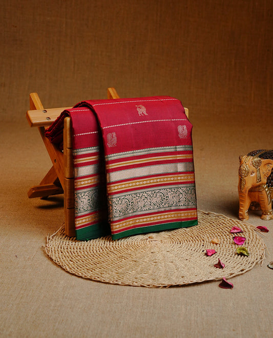 Maroon colour Kancheepuram silk saree featuring Gold Zari Peacock & stripes on body, enrich Gold Zari with Red, mustard on contrast Green border, paired with a Matching blouse piece.