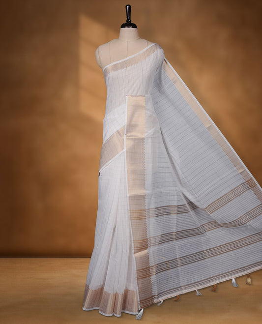 Off-white colour cotton Kerala saree featuring a classic gold kasavu border, detailed with fine woven stripes across the body and pallu, and paired with a matching blouse.