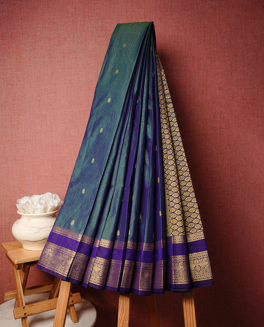 Teal colour soft silk saree featuring Gold zari Check & motifs on body, complemented by contrast indigo colour with traditional border, paired with matching blouse piece.