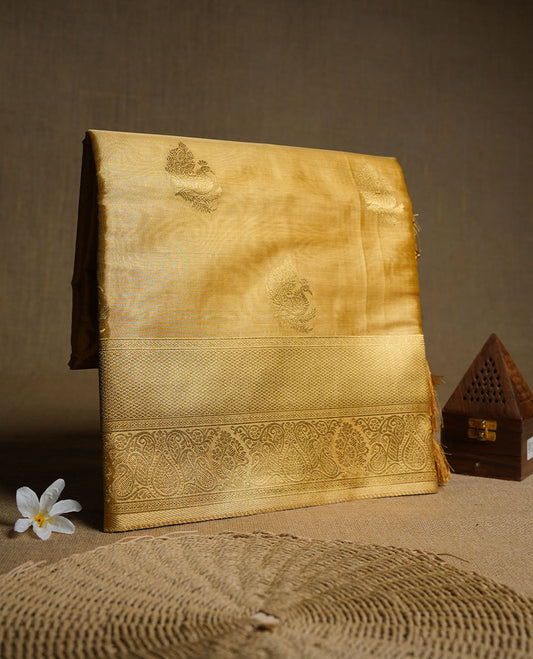 Gold colour tissue brocade saree featuring all-over zari floral motifs on the body, a rich traditional zari border and an intricately woven pallu, paired with a matching blouse piece.