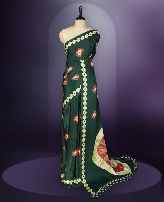 Dark green colour saree with red, white & yellow motifs, diamond border, and bold pallu & Comes with a paired matching blouse.