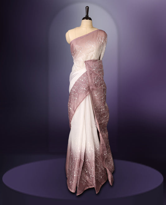 White and mauve shaded saree adorned with delicate floral threadwork across the body and border, featuring a soft ombre effect for an elegant appeal, paired with a matching blouse.