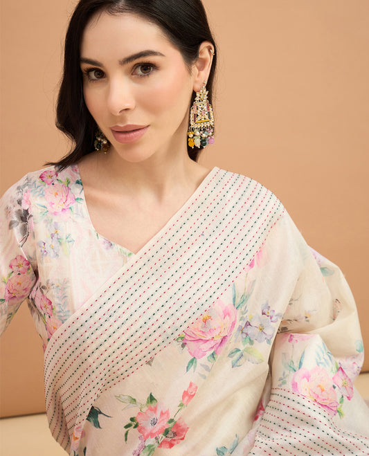 Cream toned semi tussar saree featuring delicate multicolour floral prints on the body, accented with a pastel hued Katha style stitched border and peach & pink printed pallu Comes with a matching floral printed blouse for a graceful look.