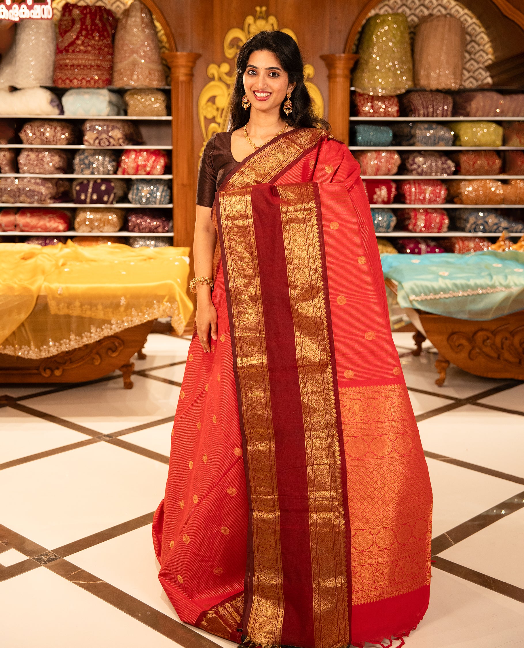 Red With Maroon Chettinad cotton saree featuring Gold zari strips with peacock motifs on body, complemented by contrast colour border with zari design & grand pallu, comes with matching blouse piece.