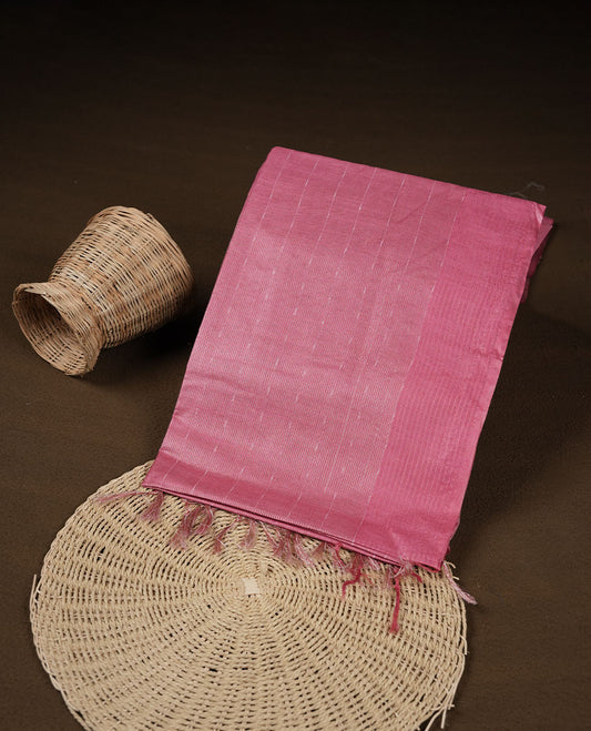 Light onion colour semi jute saree highlighting gold zari striped body, without border and paired with matching blouse.