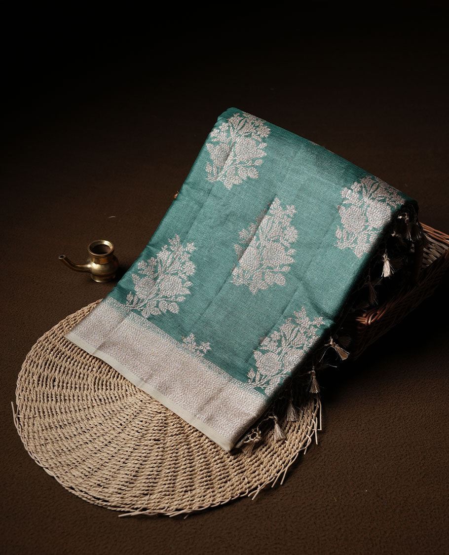 Green colour pure banaras tusser silk saree highlighting antique zari pattern across body, with contrast cream colour with zari border and paired with matching blouse