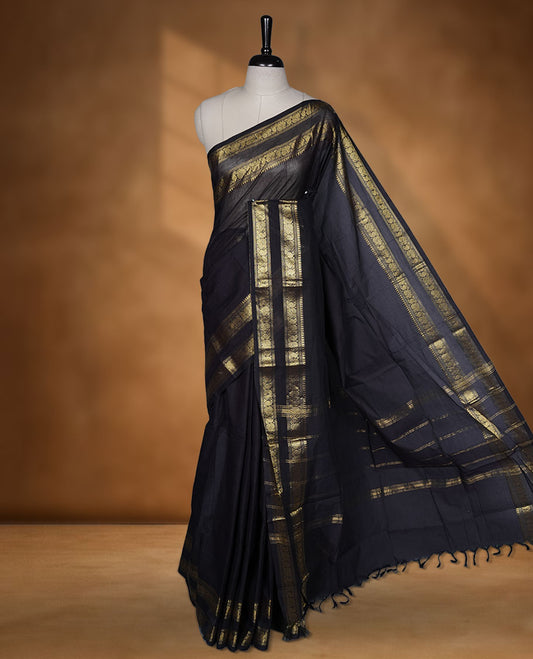 Dark Navy Blue colour chettinad cotton saree featuring plain body, with matching traditional gold zari border paired with matching blouse.