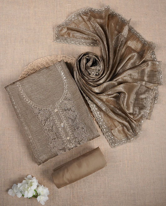 Taupe brown churidar suit material with lace embroidery and subtle sequin detailing on the neckline, paired with a matching textured dupatta and plain bottom.