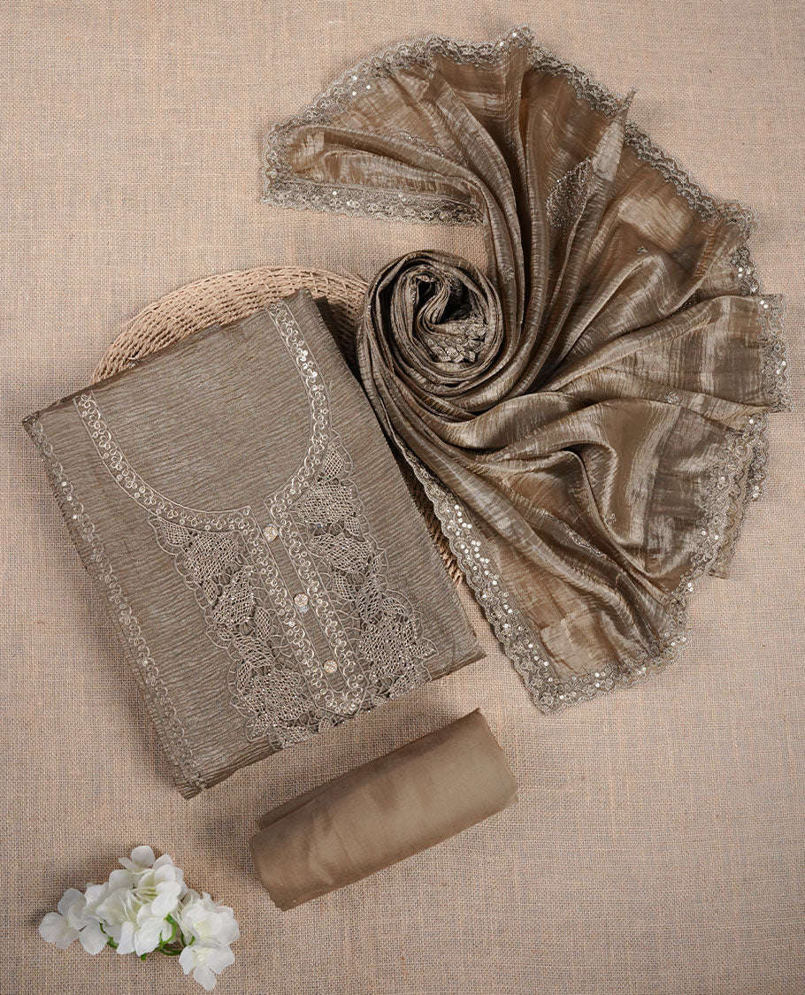 Taupe brown churidar suit material with lace embroidery and subtle sequin detailing on the neckline, paired with a matching textured dupatta and plain bottom.