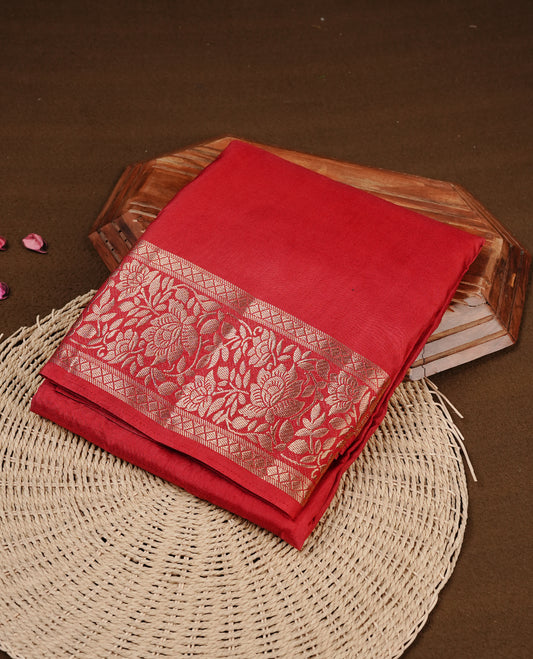 Red colour semi Tussar silk saree featuring an elegant plain body, complemented by a self colour border adorned with traditional gold zari floral kodi patterns. Comes paired with a matching blouse piece.