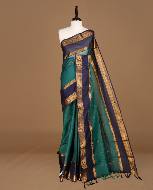 Dark green Colour Chettinad cotton saree featuring Godl zari motifs on body , complemented by contrast blue colour with traditional border, comes with matching blouse piece.