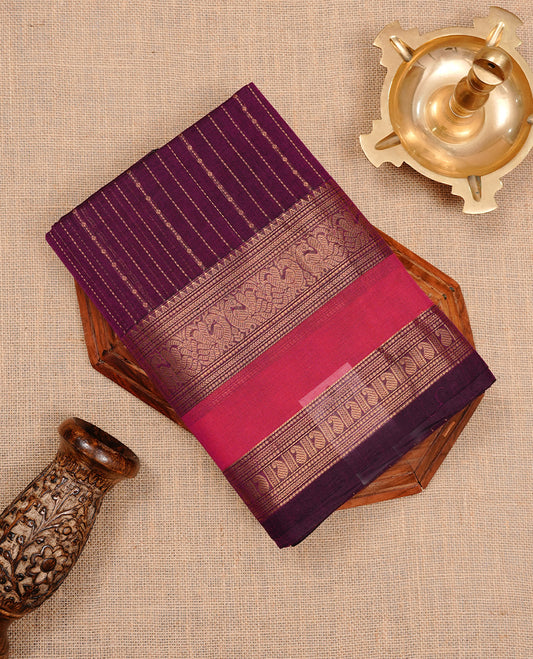 Purple colour chettinad cotton saree featuring gold zari motifs on body, complemented by magenta colour with zari border, paired with matching blouse piece.