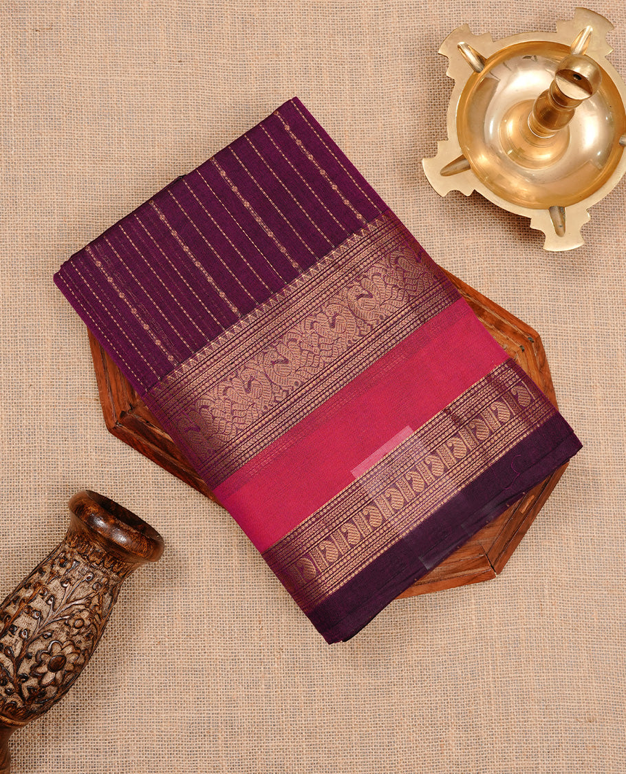 Purple colour chettinad cotton saree featuring gold zari motifs on body, complemented by magenta colour with zari border, paired with matching blouse piece.