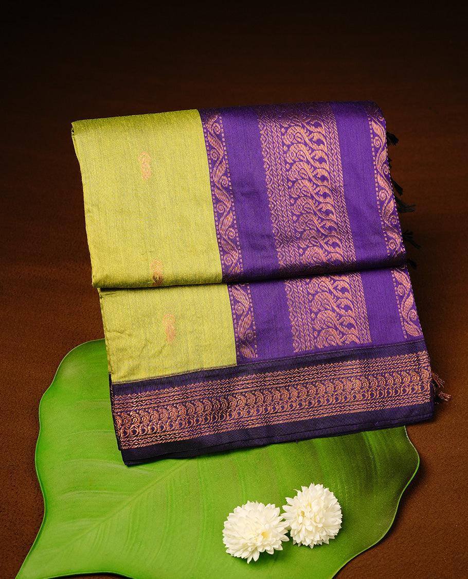 Green colour kalyani cotton saree featuring gold zari motifs on body, highlighting contrast Indigo colour with Antique gold zari border, paired with matching blouse piece.
