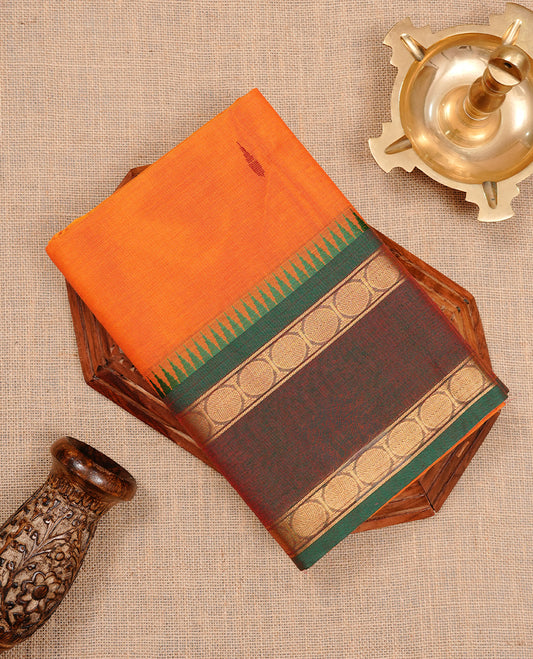 Orange colour chettinad cotton saree featuring motifs on body, complemented by Green colour with zari border, paired with matching blouse piece.