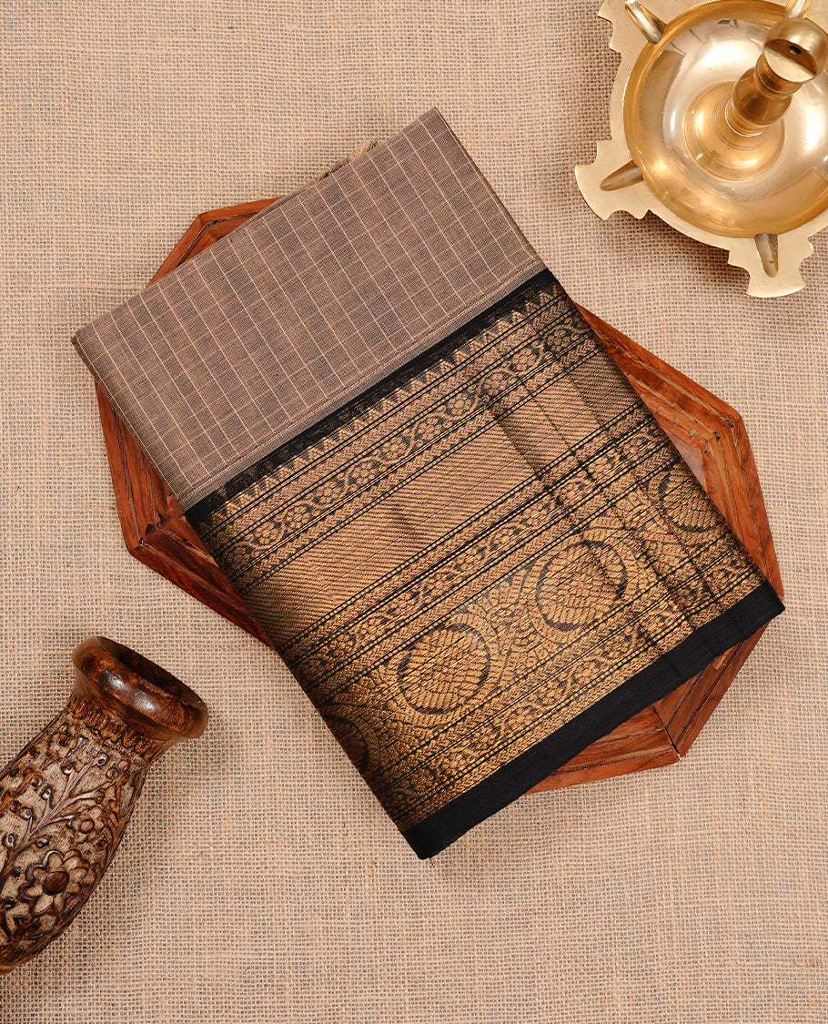 Cream tan colour chettinad cotton saree featuring gold zari motifs on body, complemented by Black colour with zari border, paired with matching blouse piece.