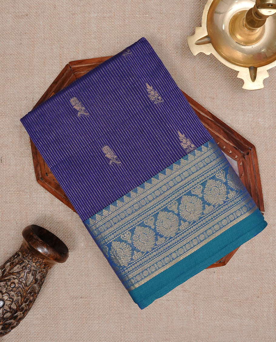 Navy blue colour chettinad cotton saree featuring gold zari stripes & motifs on body, complemented by Contrast Teal colour with zari border, paired with matching blouse piece.