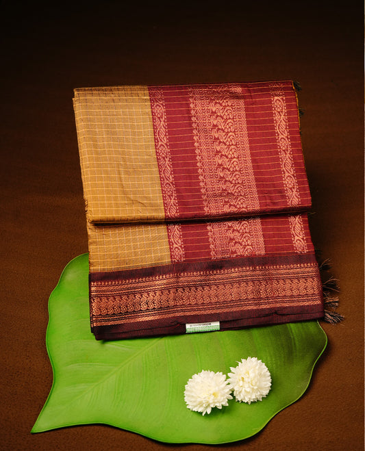 Mustard colour kalyani cotton saree featuring gold zari check pattern on body, highlighting contrast Maroon colour with Antique gold zari border, paired with matching blouse piece.