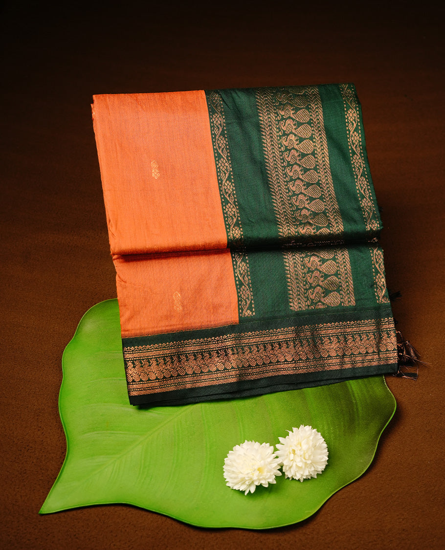 Orange colour kalyani cotton saree featuring gold zari motifs on body, highlighting contrast green  colour with Antique gold zari border, paired with matching blouse piece.