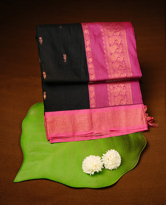 Black colour kalyani cotton saree featuring gold zari motifs on body, highlighting contrast Magenta colour with Antique gold zari border, paired with matching blouse piece.