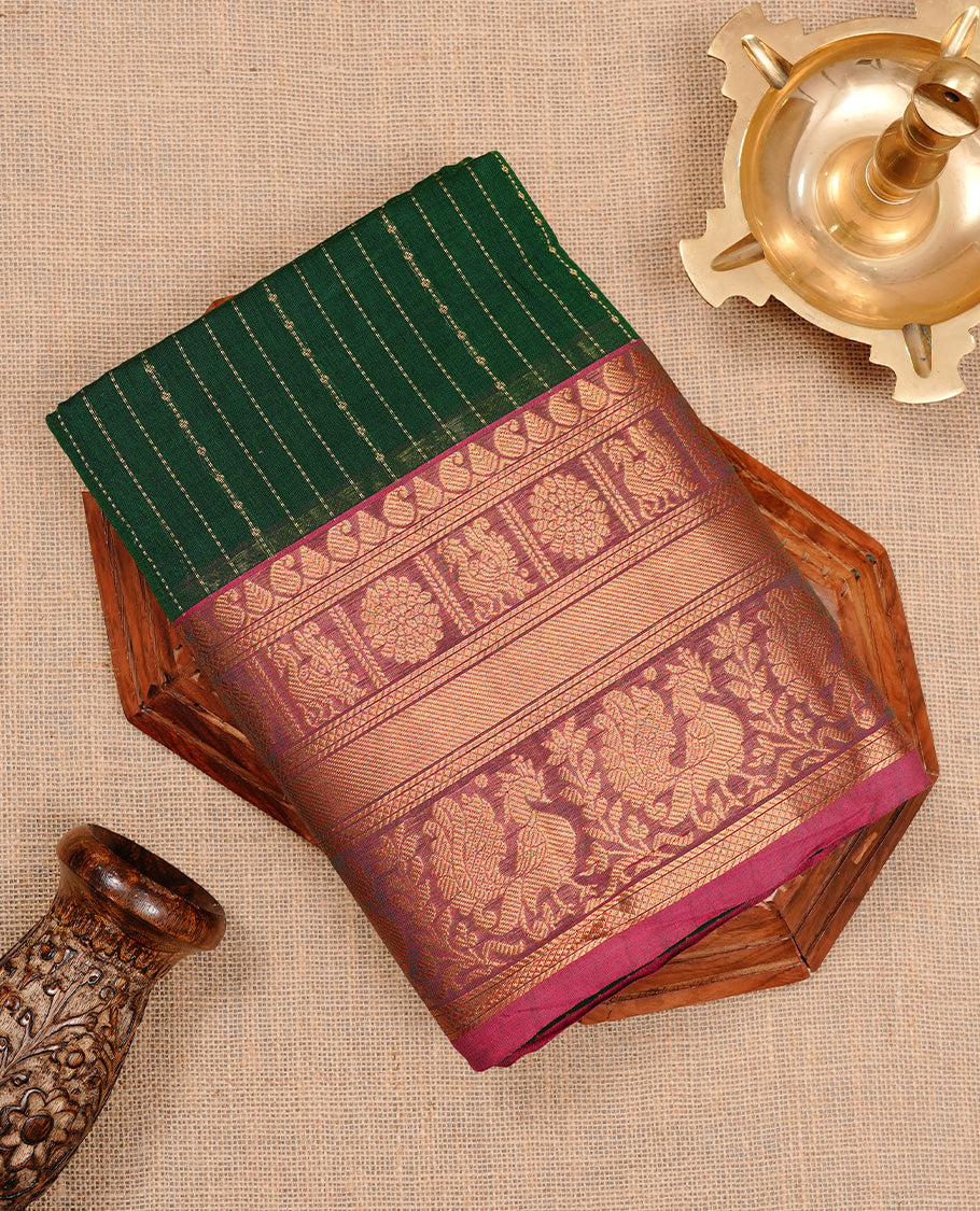 Green colour chettinad cotton saree featuring gold zari stripes on body, complemented by magenta colour with zari border, paired with matching blouse piece.