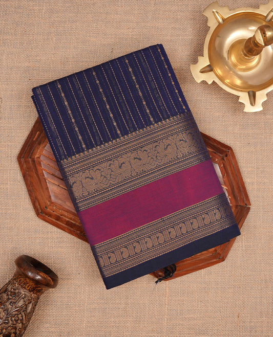 Navy blue colour chettinad cotton saree featuring gold zari stripes on body, complemented by magenta with gold zari border, paired with matching blouse piece.