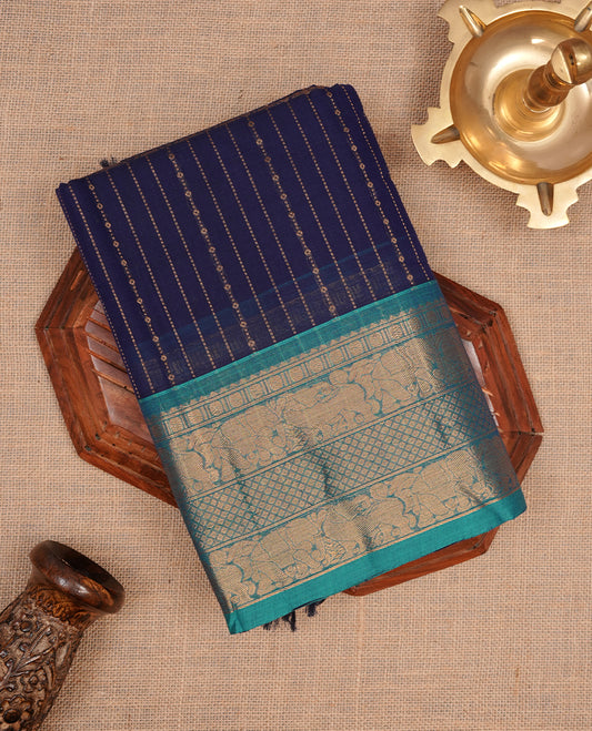 Navy blue colour chettinad saree featuring gold zari stripes on body, complemented by contrast Aqua colour with traditional border, paired with matching blouse piece.