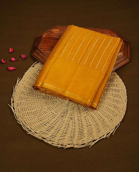 Mustard colour chettinad saree highlights gold and silver zari stripes across body,  border, pallu and paired with matching blouse piece.