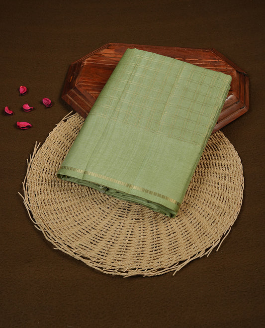 Pastel green colour semi tussar silk saree highlights gold zari check pattern across body,  border, pallu and paired with matching blouse piece.