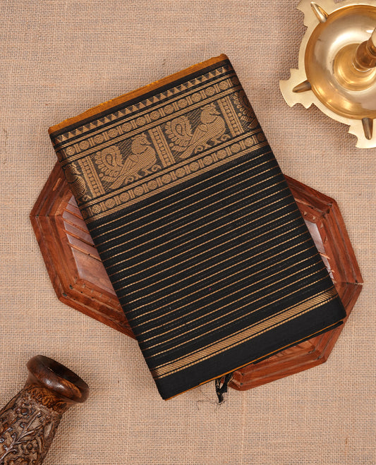 Mustard colour chettinad cotton saree featuring elegant plain body, complemented by contrast black colour with traditional border, paired with matching blouse piece.