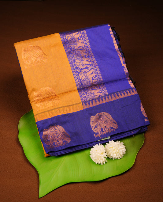 Mustard colour mixed Kalyani cotton saree with subtle zari motifs, royal blue zari border and elephant motif pallu, paired with a matching blouse.