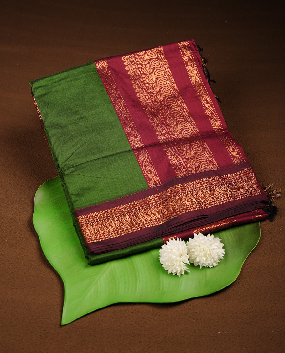 Green colour Kalyani cotton saree featuring a plain elegant body, complemented by a rich maroon zari border and traditional woven pallu, paired with a matching blouse.