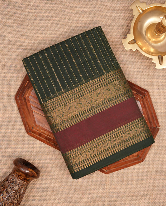 Green colour chettinad cotton saree featuring gold zari stripes on body, complemented by gold zari with maroon border, paired with matching blouse piece.