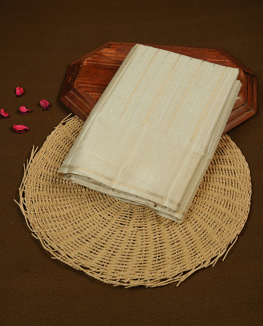 Beige colour chettinad saree highlights gold and silver zari stripes across body,  border, pallu and paired with matching blouse piece.