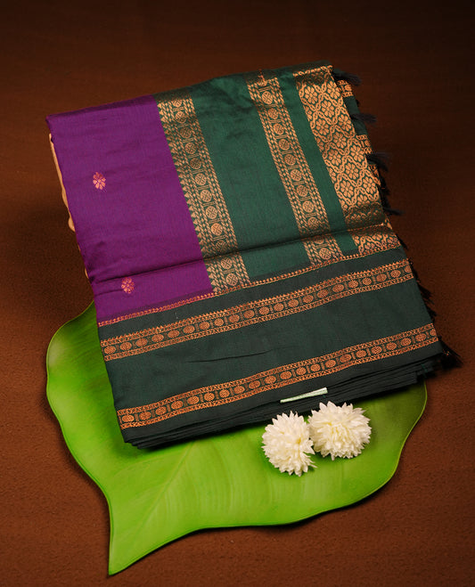 Purple colour mixed Kalyani cotton saree with subtle zari motifs, dark green zari border and rich traditional pallu, paired with a matching blouse.