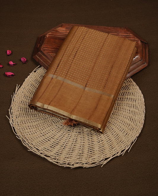 Antique gold colour chettinad saree highlighting gold zari dotted stripes, self colour border and contrast dark gold pallu and comes with matching blouse piece.