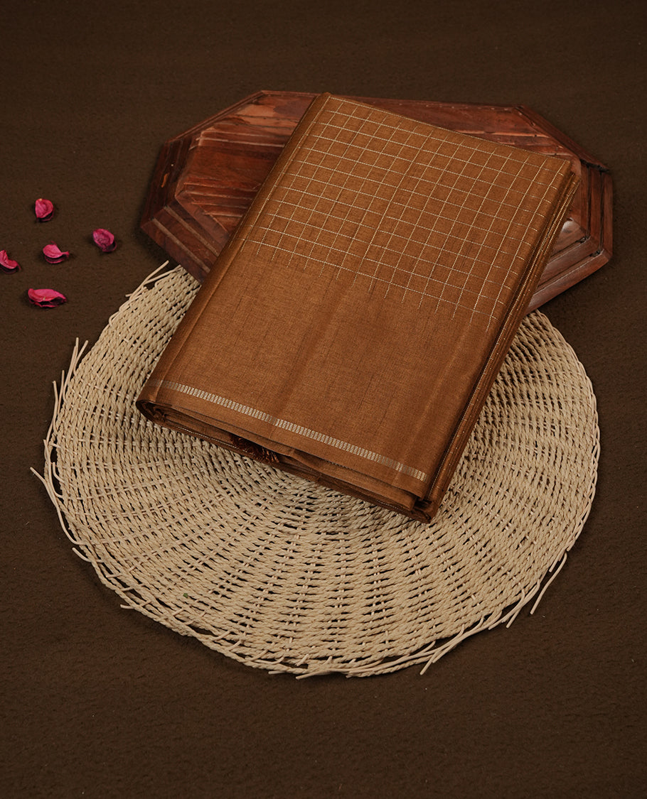 Brown colour semi Tussar saree highlights gold zari check pattern across body,  border, pallu and paired with matching blouse piece.