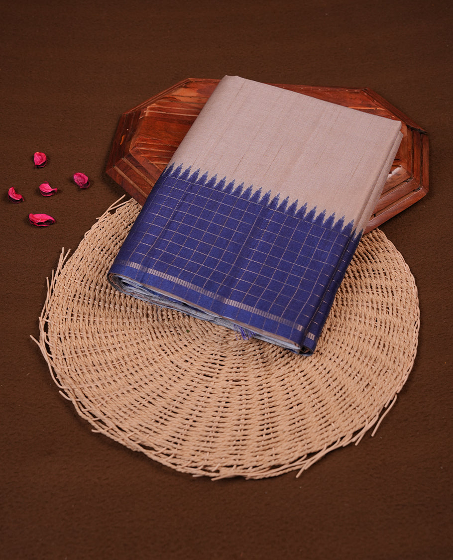 Beige colour semi tussar silk saree highlighting elegant plain body, contrast blue colour border with gold zari box pattern, pallu and comes with matching blouse piece.