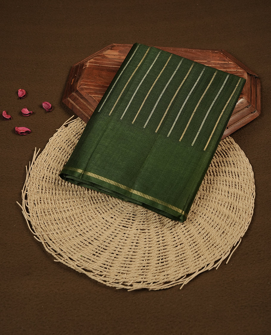 Green colour semi tussar silk saree highlights gold and silver zari stripes across body,  border, pallu and paired with matching blouse piece.