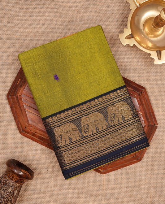 Olive green colour chettinad cotton saree featuring small buttas on body, complemented by contrast blue colour with gold zari border, paired with matching blouse piece.