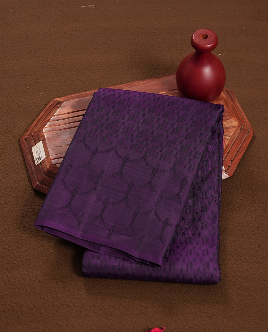 Deep violet colour semi soft silk saree featuring a self coloured textured patterned body, complemented by self coloured motifs on pallu & border and a matching blouse piece.
