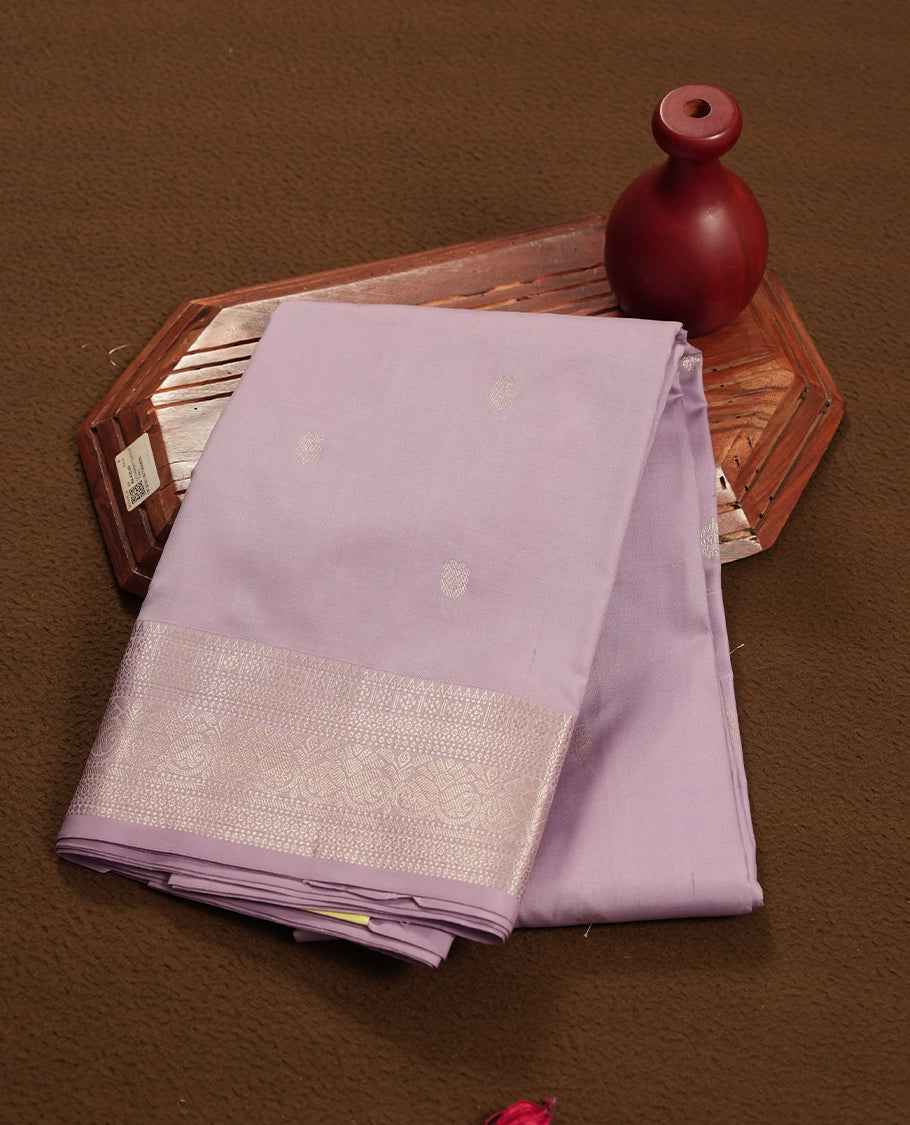 Lavender colour semi soft silk saree featuring a golden textured patterned body, complemented by self coloured golden traditional motifes on pallu & border and a matching blouse piece.