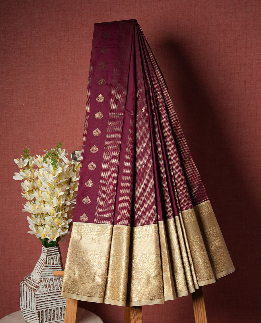 Burgundy colour Semi Silk Saree with gold zari striped patterns on the body, paired with a contrasting cream colour traditional pallu and border, and a matching blouse piece.
