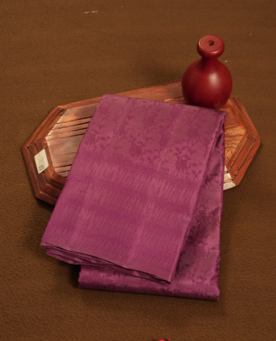 Wine colour semi soft silk saree featuring a self coloured textured patterned body, complemented by self coloured pallu & border and a matching blouse piece.
