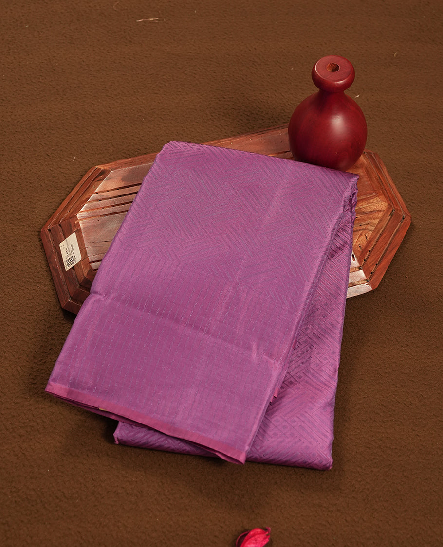 Plum purple colour semi soft silk saree featuring a self coloured textured patterned body, complemented by self coloured pallu & border and a matching blouse piece.