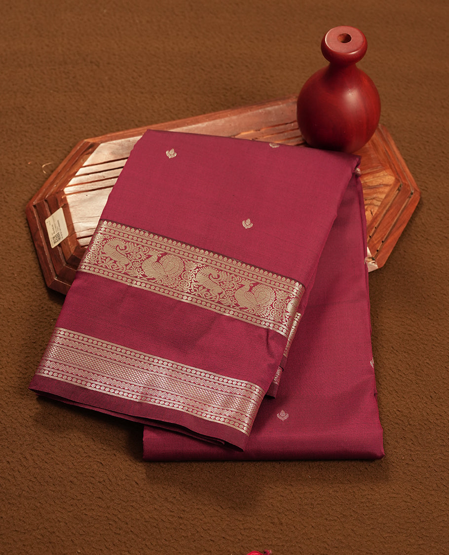 Maroon colour semi soft silk saree featuring a gold floral patterned body, complemented by gold traditional pallu & border and a matching blouse piece.