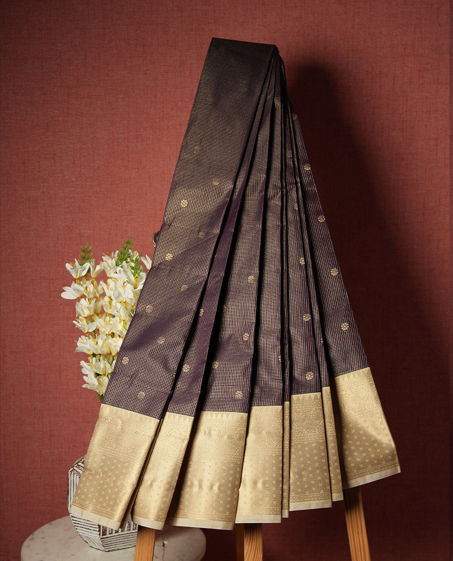 Dark grape colour Semi Silk Saree with golden checks and floral motifs on the body, paired with a contrasting cream pallu and border featuring peacock motifs, and a matching blouse piece