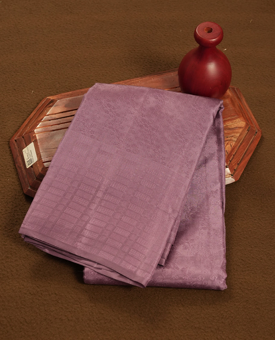 Medium grape colour semi soft silk saree featuring a self coloured textured patterned body, complemented by self coloured Square motifs on pallu & border and a matching blouse piece.
