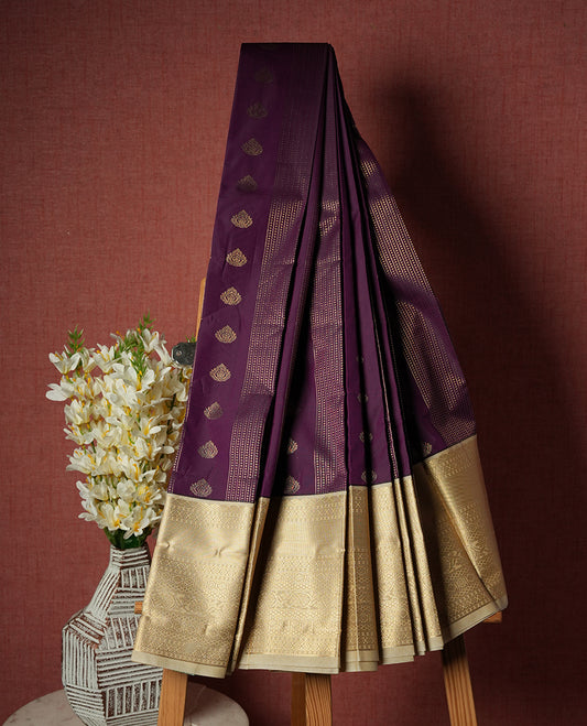 Grape purple colour Semi Silk Saree with gold zari striped patterns on the body, paired with a contrasting cream colour traditional pallu and border, and a matching blouse piece.