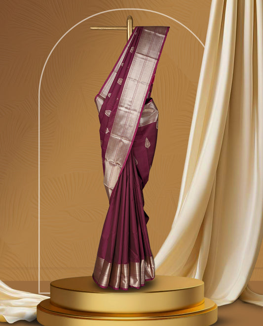 Wine colour soft silk saree beautifully adorned with silver zari buttas, paired with a rich silver zari border and pallu & Completed with a matching blouse.